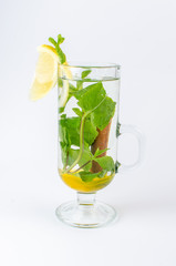tea with honey, lemon, cinnamon and mint in a clear glass