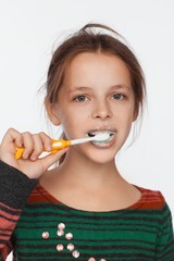 Portrait of an eight-year-old girl who brushes her teeth with a toothbrush