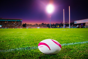 American football, rugby ball on the green grass at the stadium. Professional game in the night. Background sport photo