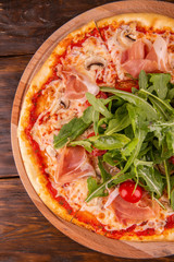 Hot pizza with Parma and arugula with champignons