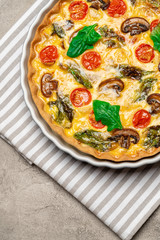 Baked homemade quiche pie in ceramic baking form