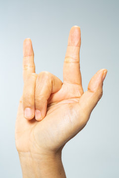 Woman's hand  symbol meaning " i love you " on grey  background, Close up & Macro shot, Selective focus, Asian body skin part, Symbol, Gesturing, Body Language, Valentine and wedding concept