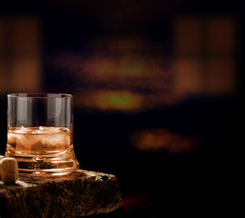 Whiskey glass on the wooden table in a dark bar