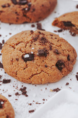 Homemade chocolate chips cookies with salt on white background, top view