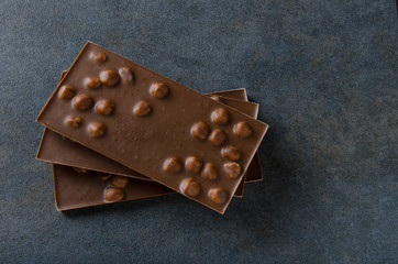Bars of milk chocolate on dark surface