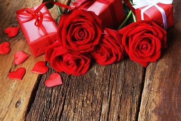 Group of lovely blooming red color rose flower on wood table background decorated with mini red heart figure, sweet valentine present concept