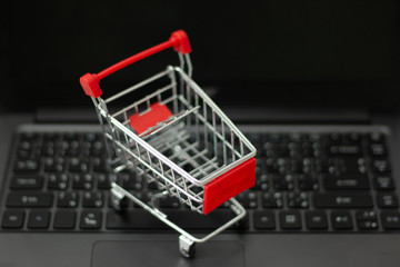 Small shopping cart on laptop for shopping online. Online shopping concept.