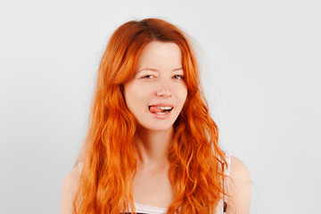 Redhead girl shows tongue and smiles