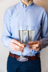 Valentines day romantic date night, handsome man holding two champagne glasses for couple.