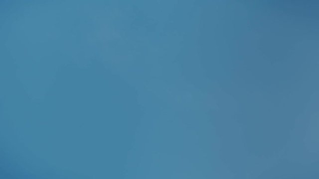 Blue clean and simple passenger airplane crosses skies from left to right on sunny summer day. Travelling and tourism concept, wanderlust destination for modern travellers and business people
