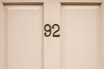 House number 92 on a white wooden front door
