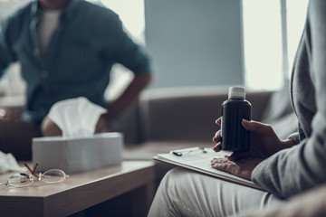 Selective focus of the psychotherapist holding a bottle of medicine