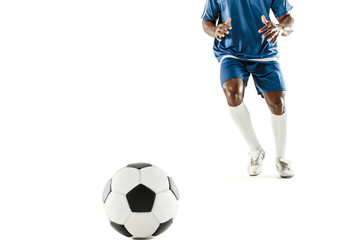 Plakat The legs of soccer player close-up isolated on white. African american model in action or movement with ball. The football, game, sport, player, athlete, competition concept