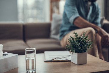 Close up of coffee table with plant and glass of water on it