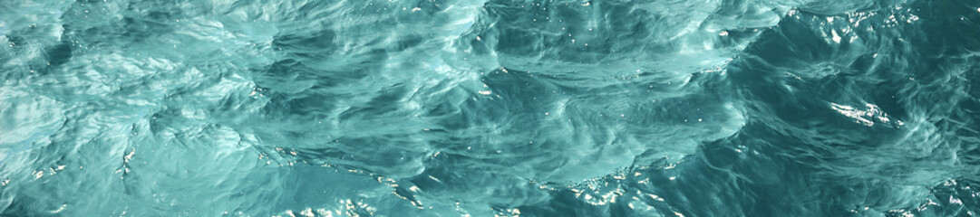 Texture eau de mer bleue avec des reflets ensoleillés, bannière panoramique design frontière