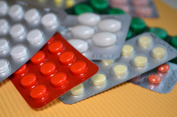 Mix of round and oval medical tablets in pack, tablets packed in blisters. Healthcare and medical concept closeup