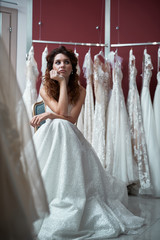 Thoughtful bride sitting in elegant wedding dress