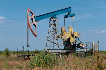 Fototapeta na wymiar Oil well site pump jack and fields at in rural
