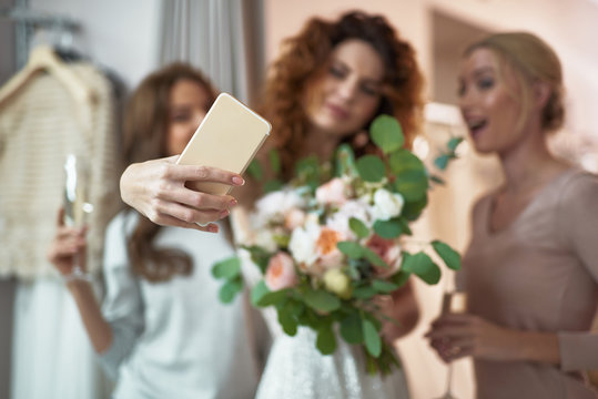 Young ladies making selfie in wedding salon