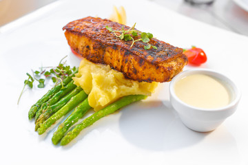 Grilled fish on top of mash potato and asparagus with cream souce