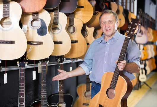 male is standing with modern guitar