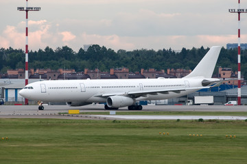 Large modern white passenger jet plane on the runway in the airport