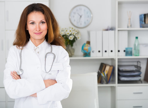 Portrait of female doctor who is working and posing on her workplace