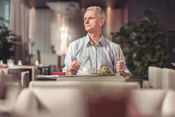 Anxious pensioner waiting for someone in a restaurant