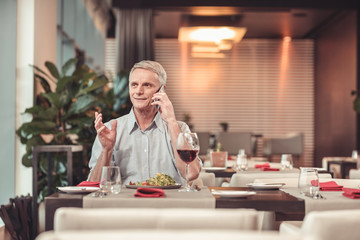 Fototapeta premium Serious man drinking wine in a restaurant