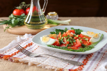 Fresh tomato salad with greens and boiled egg.