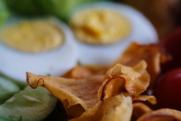 Obraz na płótnie Canvas Muslim salad with sauce on wood table and have some space for write wording, delicious appetizer with many kinds of vegetable, green leaf lettuce, onion, boiled egg, tofu, high nutrition