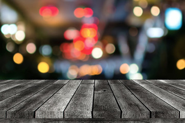 empty wooden board, table or modern wooden terrace with abstract night light bokeh of restaurant at...
