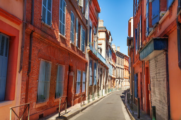 Fototapeta na wymiar Brick houses on narrow street of Toulouse, France