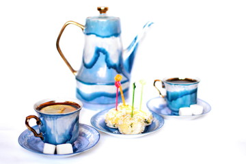 Pair vintage stylish graceful porcelain cup, dessert on plate and teapot of morning tea with slice of lemon and two pieces of sweet sugar on dish on white background. Isolated