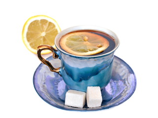 Vintage elegant stylish graceful beautiful porcelain cup with golden handle and two pieces of sweet sugar on dish of morning tea with lemon on white background with half lemon. Isolated