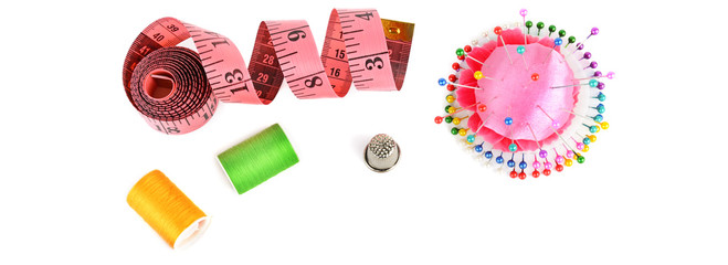 Composition with threads and sewing accessories isolated on white background. Wide photo.