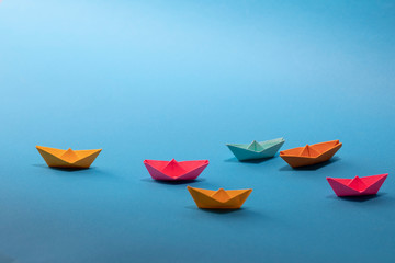 Origami paper boat, leadership concept