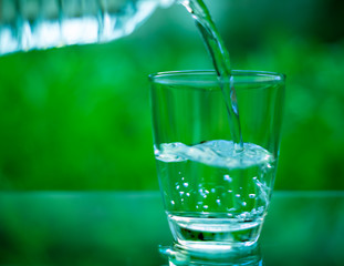 Drinking water in a glass on a wooden table