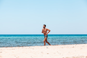 Fototapeta na wymiar Young handsome man running on the beach