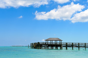 Obraz premium puste, rustykalne drewniane molo w turkusowym kolorze wody w Nassau Bahamas