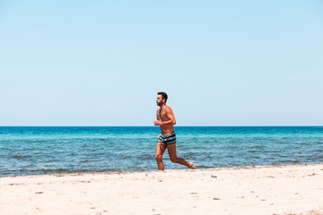 Fototapeta na wymiar Young handsome man running on the beach