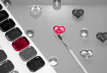 The artist paints the heart with watercolor paints.