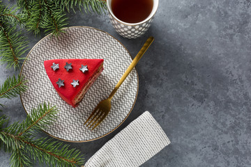 A piece of cake. Gray stone background Top view. Copy space. Decorated Christmas tree.