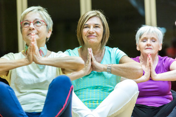 Gruppo di donne in età matura fanno yoga rilassate