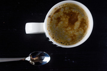 Coffee mug on a black wooden background.