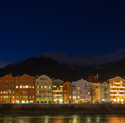 Fototapeta na wymiar Innsbruck la nuit en Autriche, reflet sur l'eau, longue exposition, façade de bâtiments typiques
