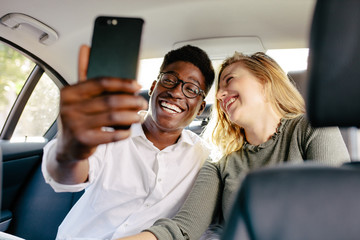 Couple traveling by a car taking selfie