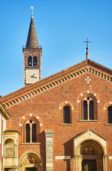 Fototapeta na wymiar Detail of the main facade of the Basilica of Saint Eustorgio. View from Piazza Sant'Eustorgio square. Milan, Lombardy, Italy.