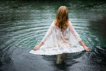 Woman walking into water, suicide concept