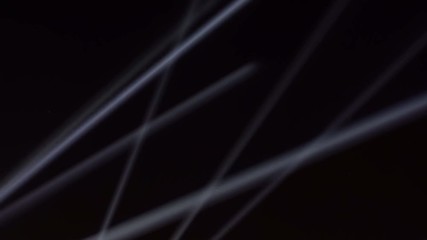 Searchlights on the night black sky.